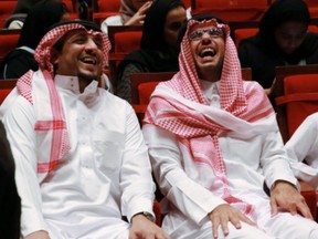 Two Saudi men laugh while enjoying the Illuminate Show.