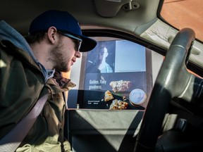 Josh McIlravey places his order at the drive-thru and is able to see who he is chatting with. There is a new Video screen that shows barista on the menu board at a Calgary Trail Starbucks drive-through on January 12, 2017.