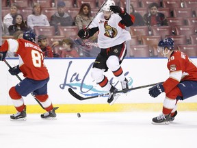 Derick Brassard of the Senators leaps over Panthers defenceman Michael Matheson's stick as they vie for the puck with Florida's Jonathan Marchessault during the first period of their game Tuesday night in Sunrise, Fla.