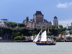 In this Aug. 5, 2015, photo, a schooner sails against the backdrop of Quebec City and the iconic Chateau Frontenac overlooking the port. Quebec City will host more than 40 tall ships July 18-23, a beauty pageant from the age of sail that will bring days of festivities and fireworks to the historic walled city.
