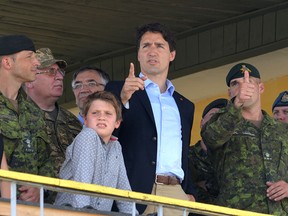 Canadian Prime Minister Justin Trudeau (C) and his son Xavier watch Ukrainian military exercises with Canadian military instructors at the International Peacekeeping and Security Center in Yavoriv, near Lviv, on July 12, 2016.