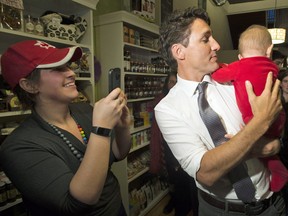 Prime Minister Justin Trudeau tries to convince a baby to turn as he visits a cafe in Napanee, Ont., on Thursday, January 12, 2017.