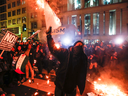 Protesters burn signs outside of the DeploraBall at the National Press Building, on Jan. 19, 2017 in Washington