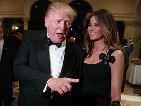 Melania Trump, right, looks on as her husband President-elect Donald Trump talks to reporters during a New Year's Eve party at Mar-a-Lago, Saturday, Dec. 31, 2016, in Palm Beach, Fla.