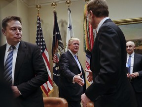 President Donald Trump greets Wendell P. Weeks, right, Chief Executive Officer of Corning, as he host breakfast with business leaders in the Roosevelt Room of the White House in Washington, Monday, Jan. 23, 2017. On the left of is Elon Musk, CEO of SpaceX and Tesla Motors