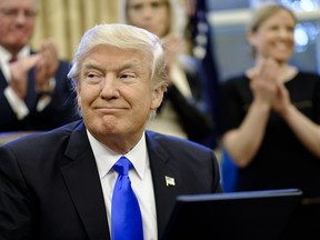 U.S. President Donald Trump smiles after signing executive orders in the Oval Office of the White House in Washington, D.C., U.S., on Saturday, Jan. 28, 2017.
