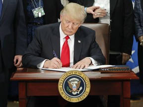 President Donald Trump signs an executive order for border security and immigration enforcement improvements, Wednesday, Jan. 25, 2017