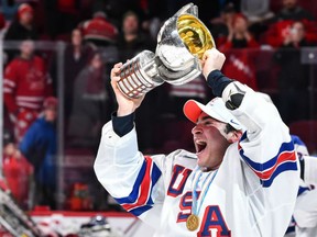 Luke Kunin of the United States holds up the championship trophy after their 5-4 shootout win over Team Canada in the final of the world junior hockey championship in Montreal on Thursday.