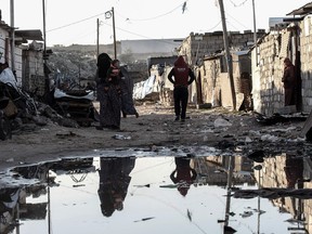 Palestinians walk through a street in an impoverished area in the southern Gaza Strip town of Khan Yunis on February 19, 2017