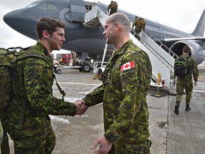 Colonel Bill Fletcher (R) shakes the hand of one of approximately 100 soldiers from 1 Canadian Mechanized Brigade Group as they depart Edmonton on Wednesday, February 22, 2017, for Poland for six months as part of Operation Reassurance to support NATO.