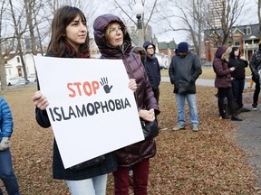 Protestors hold signs at a protest against Islamophobia at Dundonald Park in Ottawa on Sunday, December 13, 2015