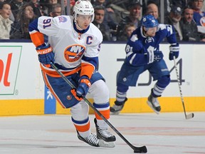 In this March 9, 2015 file photo, John Tavares (left) of the New York Islanders skates with the puck against the Toronto Maple Leafs.