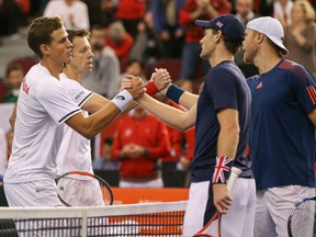 Dominic Inglot and Jamie Murray of Great Britain shake hands with Vasek Pospisil and Daniel Nestor of Canada after their win in the doubles match on Day 2 of their Davis Cup World Group match at TD Place Arena in Ottawa on Saturday.