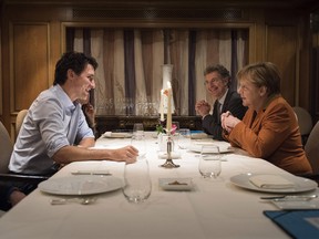 Angela Merkel sits across the table for dinner with Justin Trudeau and next to Christoph Heusgen, German foreign and security policy adviser, February 16, 2016 in Berlin, Germany