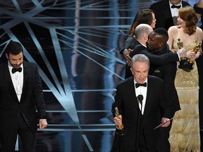 Actor Warren Beatty (R) announces the actual Best Picture winner as 'Moonlight,' not 'La La Land,' after a presentation error onstage during the 89th Annual Academy Awards at Hollywood & Highland Center on February 26, 2017 in Hollywood, California.