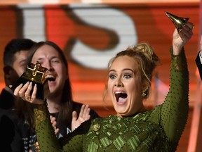 Adele wins Album of the Year and accidentally breaks her trophy at the Grammys.
