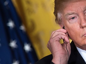 Donald Trump listens to a translation of Japan's Prime Minister Shinzo Abe's comments during a press conference in the East Room of the White House February 10, 2017 in Washington, DC.