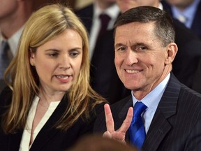 US National Security Advisor Michael Flynn flashes the v-sign on January 22, 2017 while awaiting the arrival of  US President Donald Trump for the swearing-in of the White House senior staff.