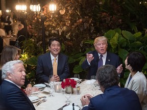 US President Donald Trump, Japanese Prime Minister Shinzo Abe (2nd-L), his wife Akie Abe (R), US First Lady Melania Trump (L) and Robert Kraft (2nd-L),owner of the New England Patriots, sit down for dinner at Trump's Mar-a-Lago resort on February 10, 2017.