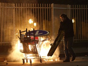 A man walks by a fire during a protest in Bobigny, a district of northeast Paris, to denounce police brutality. One officer has been charged with rape and three others with assault after a black man required surgery after he claims he was raped by one of the officer's batons during an arrest Feb. 2.