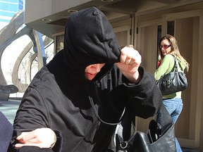 Andrea Giesbrecht tries to hide from the media as she leaves the Law Courts in Winnipeg, Man. on April 21, 2016.