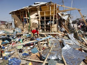 A shopkeeper surveys the wreckage of shops destroyed by a blast in a market in the capital Mogadishu, Somalia Sunday, Feb. 19, 2017.