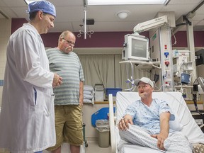 In this June 10, 2016 photo provided by the Mayo Clinic, Andy Sandness, right, talks with his father, Reed Sandness, and Dr. Samir Mardini, left, before Andy's face transplant procedure at the Mayo Clinic in Rochester, Minn. In the process leading up to the surgery, Mardini tried to temper his patient's enthusiasm. "Think very hard about this," he said. Only a few dozen transplants have been done around the world, and he wanted Andy to understand the risks and the aftermath: a lifelong regimen of anti-rejection drugs. But Sandness could hardly contain himself. "How long until I can do this?" he asked.