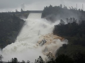 Water flows through break in the wall of the Oroville Dam spillway, Thursday, Feb. 9, 2017