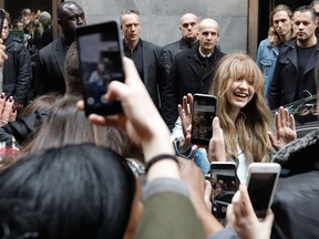 Model Gigi Hadid, right, waves to fans as she leaves after attending a presentation for Tommy Hilfiger women's Fall 2017 collection in Milan, Italy on Feb. 24, 2017.