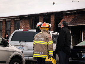 Investigators at the site of a fatal house fire in Brampton, Ont., on Tuesday.