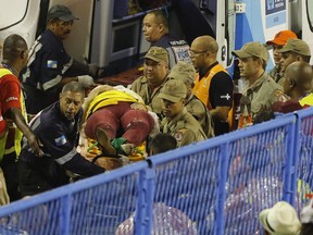 Firefighters carry an injured person on a stretcher during Carnival celebrations at the Sambadrome in Rio de Janeiro, Brazil.