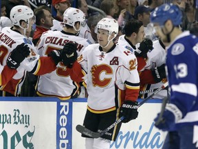 Sean Monahan of the Calgary Flames receives congratulations from his teammates after scoring his 100th career goal in Thursday's 3-2 victory over the Tampa Bay Lightning in NHL action in Tampa.