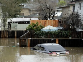Cars and backyards are flooded in a neighbourhood Tuesday, Feb. 21, 2017, in San Jose, Calif.