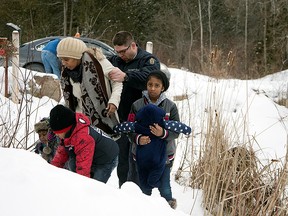 A woman who told police that she and her family were from Sudan is taken into custody by a Royal Canadian Mounted Police (RCMP) officer after arriving by taxi and walking across the U.S.-Canada border into Hemmingford, Quebec, Canada February 12, 2017. Picture taken February 12, 2017.
