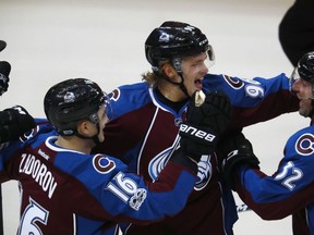 Mikko Rantanen, centre, celebrates his goal with Colorado Avalanche teammates Nikita Zadorov, left, and Francois Beauchemin against the Montreal Canadiens during the first period of their game Tuesday night in Denver.