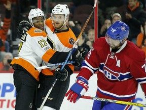 Sean Couturier celebrates his third-period empty-net goal with Flyers teammate Wayne Simmonds as Montreal Canadiens' Andrei Markov skates by during their game Thursday night in Philadelphia.