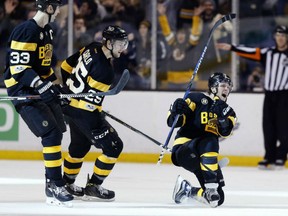 David Pastrnak celebrates his game-winning goal beside Bruins teammates Zdeno Chara and Brandon Carlo during the third period of their game against the Vancouver Canucks in Boston on Saturday. The Bruins won 4-3.