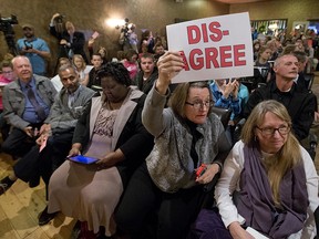 Constituents of Congressman Dave Brat, R-Va., hold signs as he answers questions during a town hall meeting with the congressman in Blackstone, Va., Tuesday, Feb. 21, 2017.