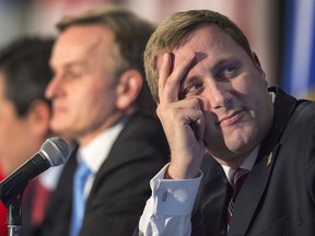 Leadership hopeful Brad Trost, sitting at one end of the stage, views the action on a projection screen at the Conservative leadership candidates' debate, in Halifax on Saturday, Feb. 4.