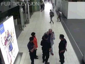 In this image made from Feb. 13, 2017, footage from Kuala Lumpur airport security cameras obtained by Fuji TV, Kim Jong Nam, exiled half-brother of North Korea's leader Kim Jong Un, gestures towards his face while talking to airport security and officials at Kuala Lumpur International Airport, Malaysia. Kim Jong Nam, the estranged half brother of North Korean ruler Kim Jong Un, died last week after apparently being poisoned in a Kuala Lumpur airport.