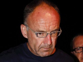Douglas Garland is escorted into a Calgary police station in connection with the disappearance of Nathan O'Brien and his grandparents in Calgary, Alta., on July 14, 2014.
