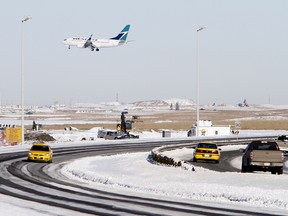 An airplane flies over traffic on Barlow Trail in Calgary on Tuesday February 8, 2011