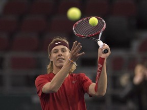 Canada's Denis Shapovalov passes balls to a coach during a practice session for the Davis Cup in Ottawa on Feb. 1.