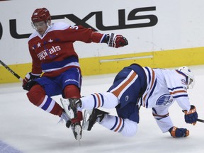 Evgeny Kuznetsov, left, of the Washington Capitals, gets tangled up with Edmonton Oilers' Connor McDavid during NHL action Friday in Washington. The Caps made it 13 straight wins on home ice with a 2-1 victory over the Oilers.