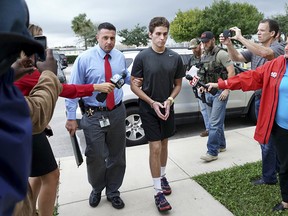 In this Monday, Oct. 3, 2016, file photo, Austin Harrouff is transported by detectives to the Martin County Jail from St. Mary's Hospital in Florida.