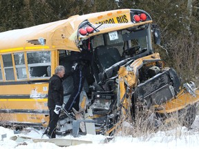 The driver of the bus and OPP officer retrieve documents. There were no injuries after a CP Rail freight train collided with a bus on Town Line Road in Cramahe Township east of Cobourg, Ont. on February 13, 2017.