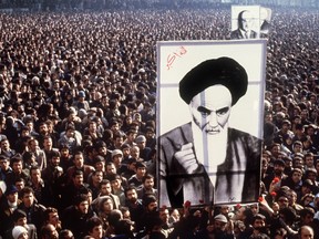 In a file picture taken in January 1979, Iranian protestors hold a up a poster of Ayatollah Ruhollah Khomeini during a demonstration in Tehran against the Shah