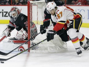 Calgary Flames' Michael Frolik tries to score against Carolina Hurricanes goalie Eddie Lack during the first period in Raleigh, N.C., Sunday.