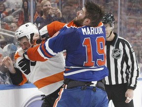 Edmonton Oilers' Patrick Maroon, right, gets physical with Philadelphia Flyers' defenceman Brandon Manning during NHL action Thursday in Edmonton. The Oilers were 6-3 winners.