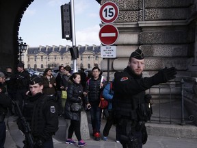 Tourists leave the Louvre museum protected by police forces in Paris.
